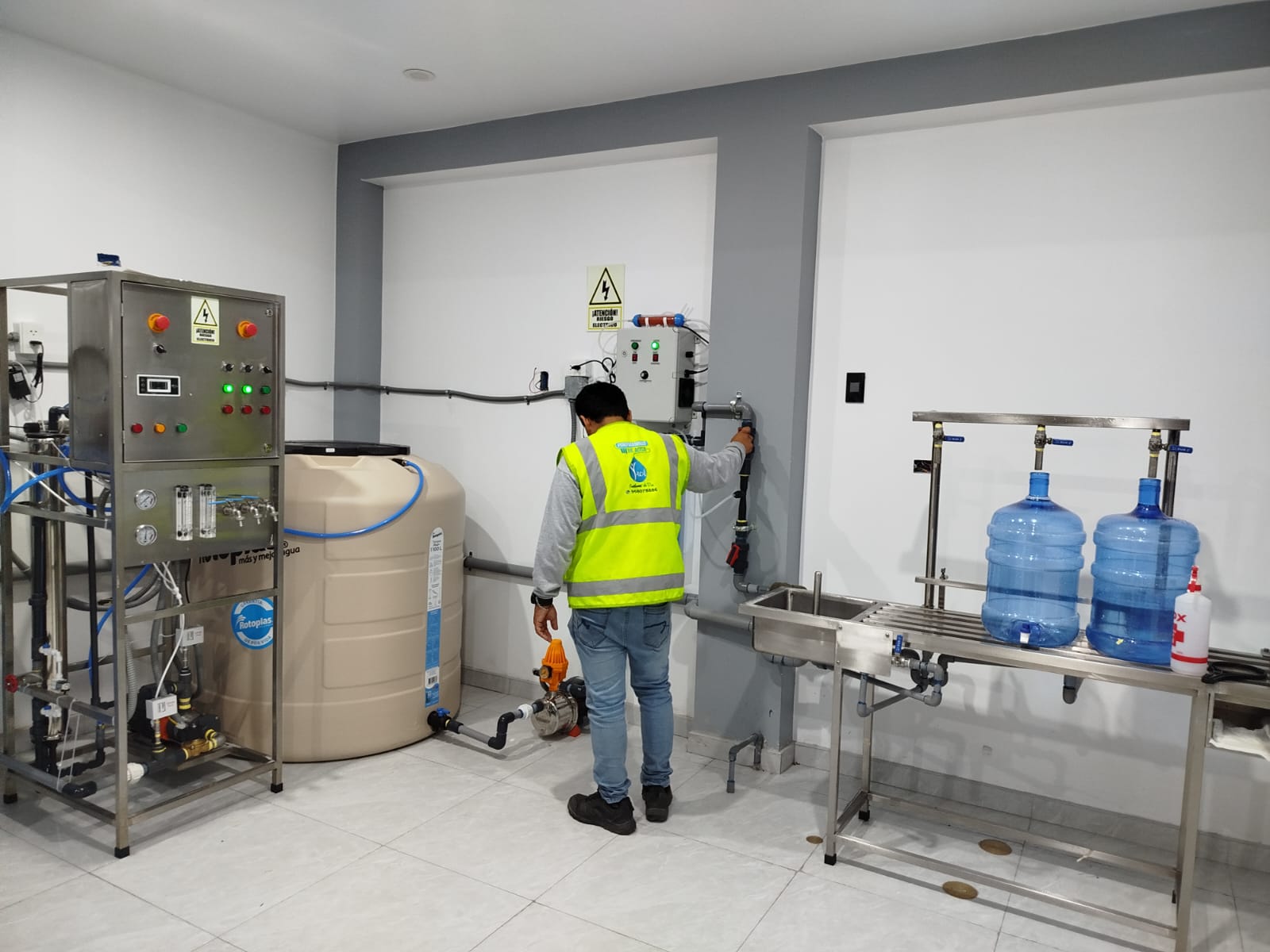 Técnico de Yacu Import supervisando una planta de tratamiento de agua y línea de llenado de bidones